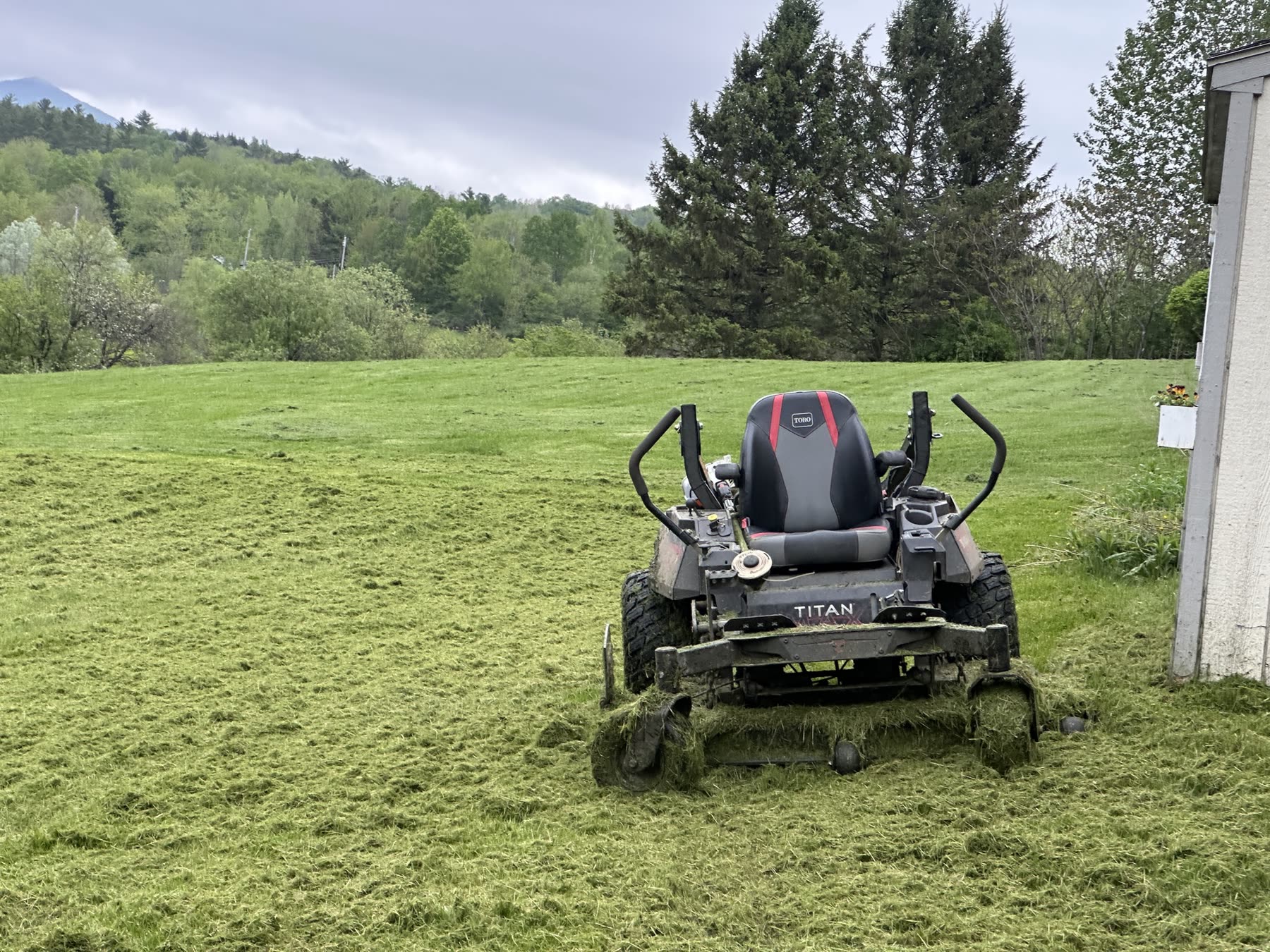 Zero-turn mower on a cut lawn with mountains behind